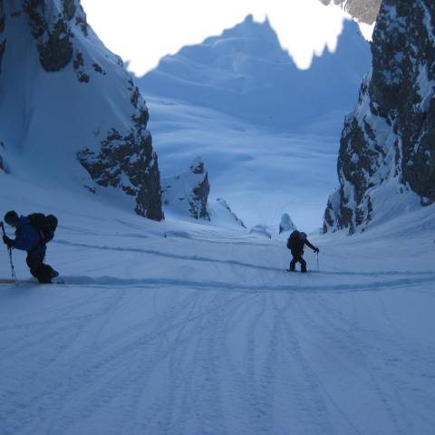 a group of people riding skis down a snow covered mountain