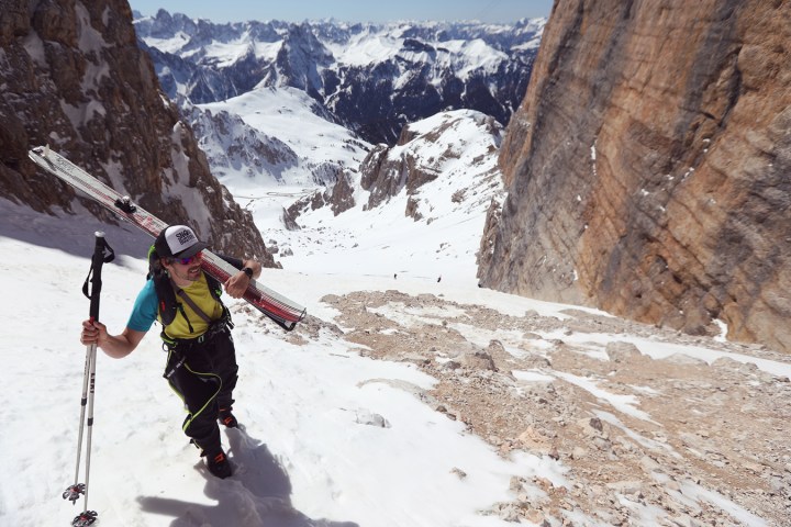 a man riding skis down a snow covered mountain