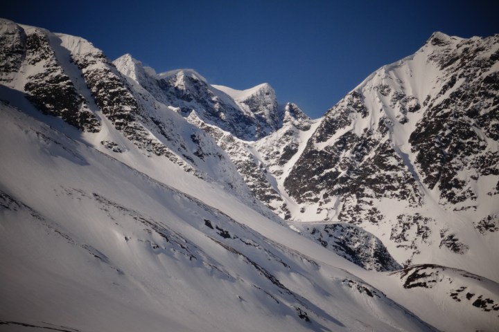 Snow-covered mountain peaks under a clear blue sky.