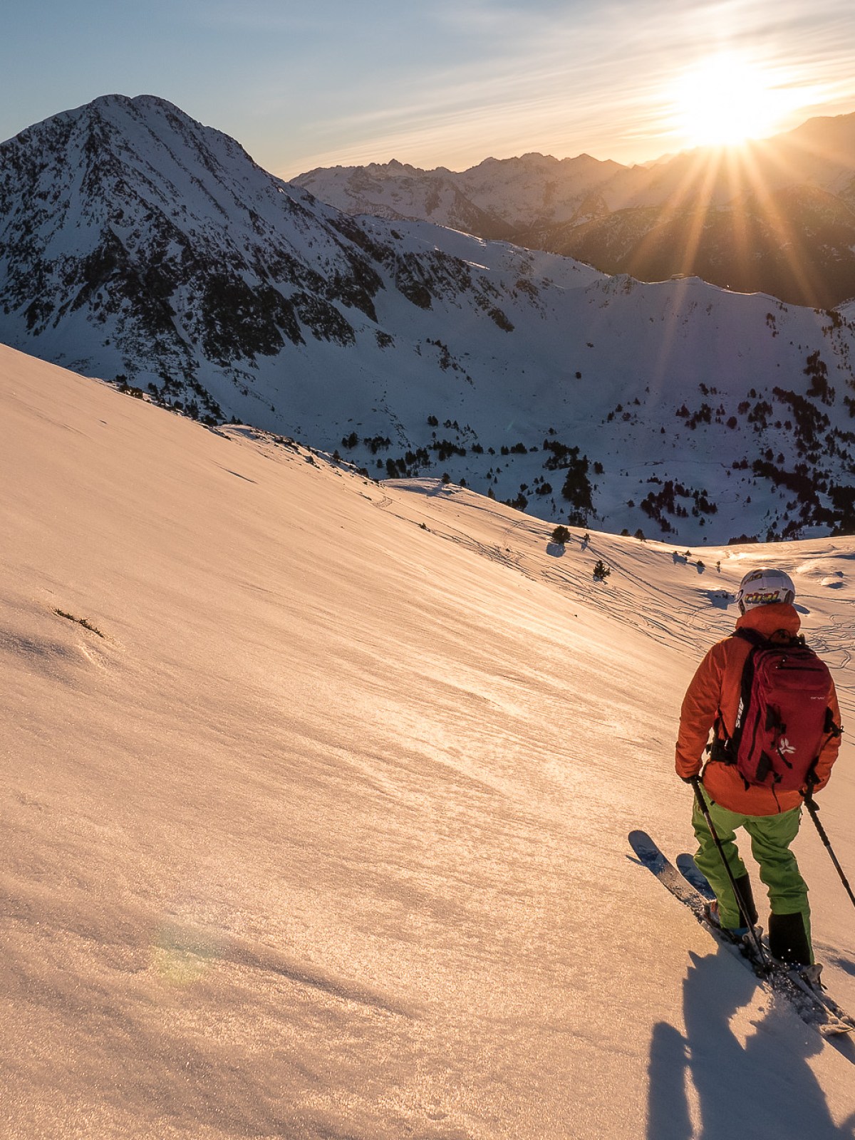 a man riding skis down a snow covered mountain