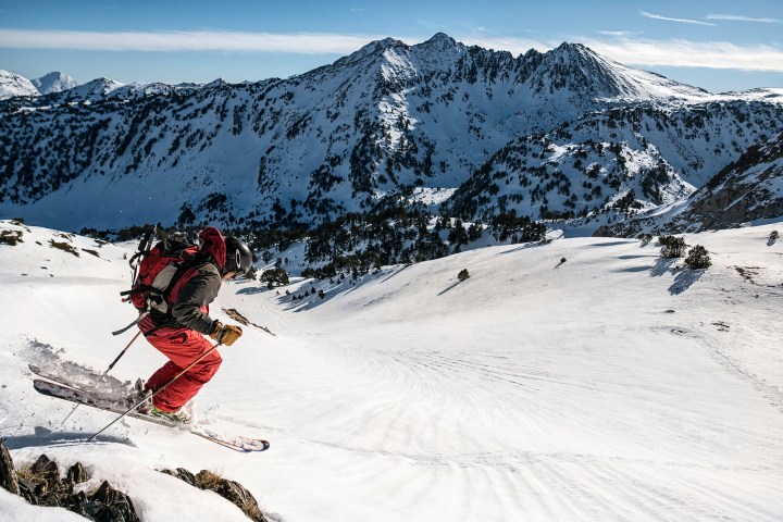 a man riding skis down a snow covered mountain