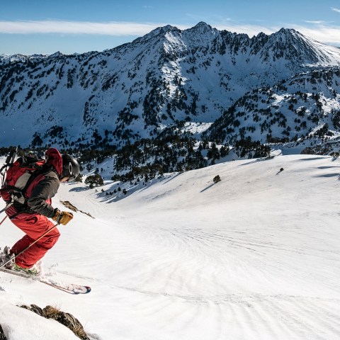 a man riding skis down a snow covered mountain