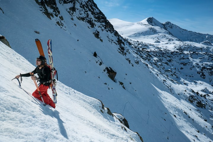 a man skiing down the side of a snow covered slope