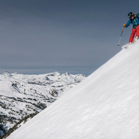 a man riding skis down a snow covered slope