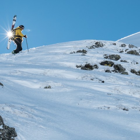 a man flying through the air on a snow covered slope
