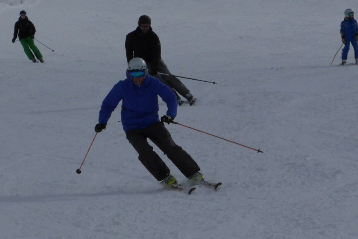 a group of people skiing down a snow covered slope