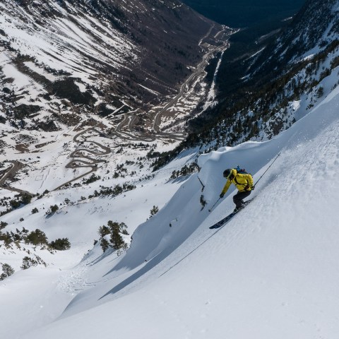 a man skiing down the side of a snow covered mountain