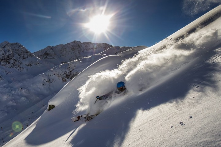 a man riding skis down a snow covered slope