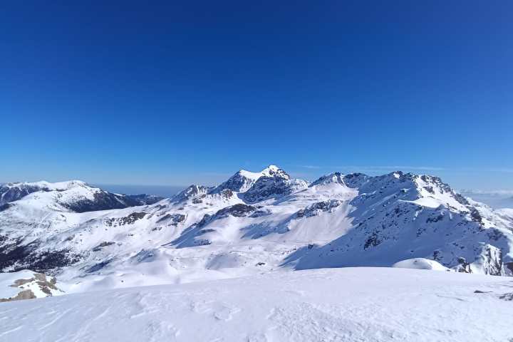 Snow-covered mountains under a clear blue sky.