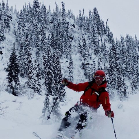 a man riding skis down a snow covered slope